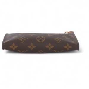 May include: Brown and tan zippered pouch with a repeating pattern of four-petal flowers and circles. The pouch is rectangular and has a brown zipper pull. The background is white.