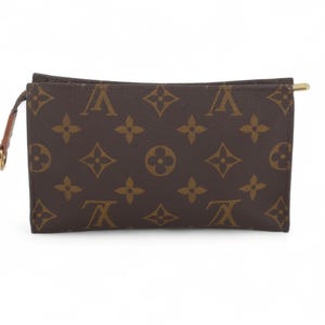 May include: Brown and tan rectangular pouch with a repeating pattern of interlocking floral and logo designs. The pouch has a gold-toned zipper and a small brown leather pull tab with a gold-toned ring. The pouch is likely made of leather.