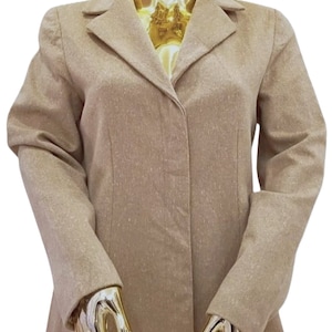 Op de afbeelding: Een beige blazer met een reverskraag en lange mouwen. De jas wordt getoond op een gouden mannequin. De blazer heeft een sluiting met één knoop en een getailleerde pasvorm. De stof heeft een subtiele textuur.