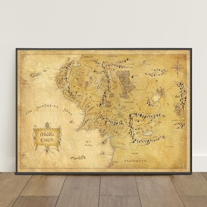 May include: A rectangular map of Middle-earth printed on aged, parchment-style paper with a dark frame. The map features detailed black ink illustrations of mountains, forests, and coastlines, with the text Middle Earth in a decorative scroll.