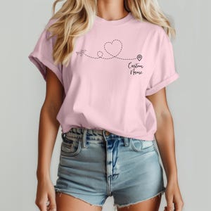 a woman wearing a pink t - shirt with the word love written on it