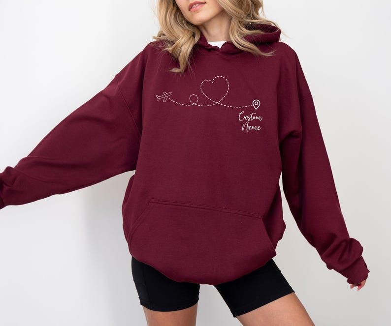 a woman wearing a maroon hoodie with a heart on it