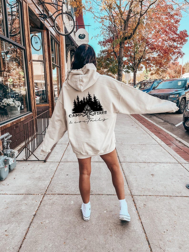 A black graphic on the back, shown on a beige hooded sweatshirt
