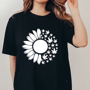 May include: Black oversized t-shirt with a white sunflower and marijuana leaf design.