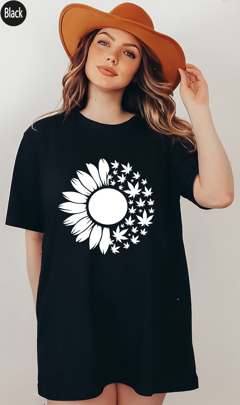 May include: Black oversized t-shirt with a white sunflower and marijuana leaf design.