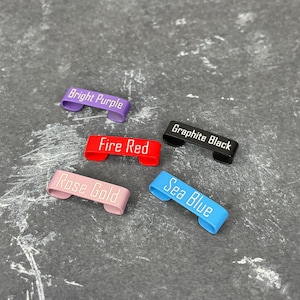 May include: Five metal keyrings in different colours with white text. The colours are bright purple, fire red, rose gold, sea blue, and graphite black. The text on the keyrings reads "Bright Purple", "Fire Red", "Rose Gold", "Sea Blue", and "Graphite Black".