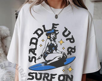 サドルアップ＆サーフィン ワイルドウェストカントリー カウガール ビーチサーファーのフレーズと格言 レトロビンテージTシャツ、ボヘミアンサマー、サーフィンシャツ、ビーチTシャツ