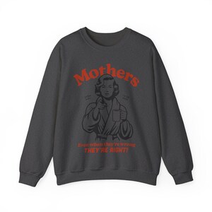 Op de afbeelding: Donkergrijze trui met een rode afbeelding van een vrouw in een badjas die een mok vasthoudt. De tekst luidt "Mothers" en "Even when they're wrong THEY'RE RIGHT!"