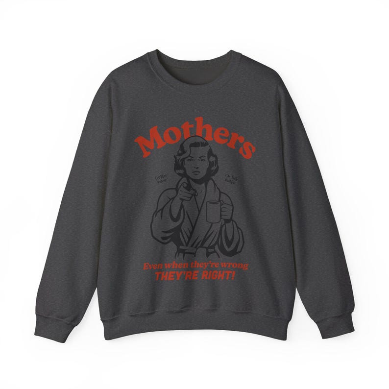 Op de afbeelding: Donkergrijze trui met een rode afbeelding van een vrouw in een badjas die een mok vasthoudt. De tekst luidt "Mothers" en "Even when they're wrong THEY'RE RIGHT!"