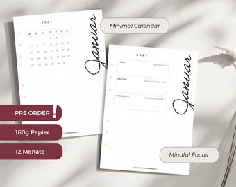 May include: Two white planner pages titled MONATS DASHBOARDS 2027 with the word Januar in script. One page shows a 2027 calendar, the other has sections for Mind, Me Time, and Work/Life. Both pages feature dot grid paper and binder holes.