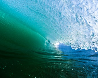 May include: A close-up view of a breaking wave, showing the turquoise and blue water inside the wave. The wave is breaking over a dark blue ocean.