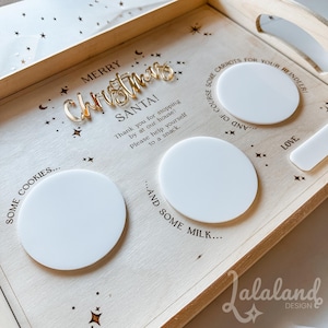 May include: A wooden tray with the words "Merry Christmas" and "Santa!" in gold lettering. The tray has four white circles for cookies, milk, carrots, and a note for Santa. The tray is decorated with stars.