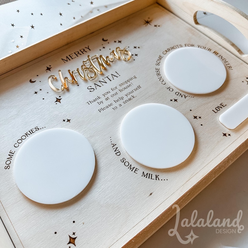 May include: A wooden tray with the words "Merry Christmas" and "Santa!" in gold lettering. The tray has four white circles for cookies, milk, carrots, and a note for Santa. The tray is decorated with stars.