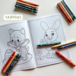 May include: A coloring book with two illustrations, a cat and a bunny, with crayons in red, yellow, blue, and green. The book has the word "Crayons" printed on the cover.