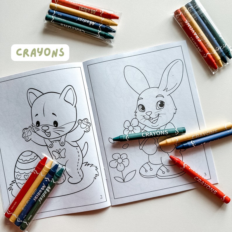 May include: A coloring book with two illustrations, a cat and a bunny, with crayons in red, yellow, blue, and green. The book has the word "Crayons" printed on the cover.