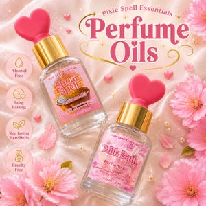 May include: Two clear glass perfume oil bottles with gold caps and pink heart-shaped toppers. One label reads Sugar Spell Perfume Oil 0.5 fl oz 15 ml, the other Milk Bath Perfume Oil 1.0 fl oz 30 ml. Text includes Pixie Spell Essentials Perfume Oils.
