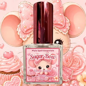 May include: A clear glass perfume bottle with a dark metallic cap, featuring a rectangular label with the text Pixie Spell Essentials Sugar Bow Eau de Parfum 0.5 fl oz | 15 ml, decorated with a pink cartoon mouse, cupcakes, and hearts.