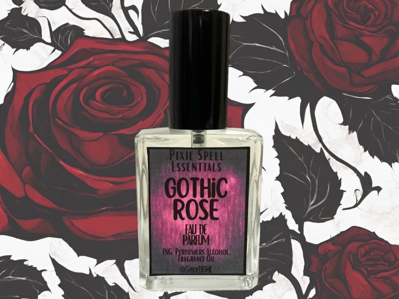May include: A clear glass perfume bottle with a black cap and a rectangular label. The label reads Pixie Spell Essentials, Gothic Rose, Eau de Parfum, Ing. Perfumers Alcohol, Fragrance Oil, 0.5 fl oz, 15 ml, against a background of red roses.
