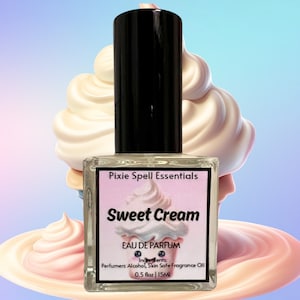 May include: A clear glass bottle with a black cap and a white label. The label says "Pixie Spell Essentials Sweet Cream Eau de Parfum Ingredients: Perfumers Alcohol, Skin Safe Fragrance Oil 0.5 fl oz | 15ML".