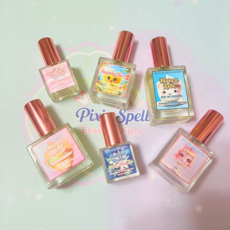 May include: Six rectangular glass perfume bottles with metallic rose gold caps and colorful labels. The labels feature text including "Sugar Spell," "Sweety Bird," "Blanca Latte," "Midnight Blooms," and "Queen," each with unique illustrations and branding.