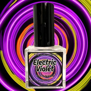 May include: A clear glass bottle with a black cap and a white label that reads "Pixie Spell Essentials Electric Violet Eau de Parfum Lavender Perfume Alcohol Safe Soft Fragrance Oil 1 fl oz / 30 ml".