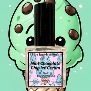May include: A small glass bottle of mint chocolate chip ice cream scented perfume. The bottle has a black cap and a white label with the text "Pixie Spell Essentials", "Mint Chocolate Chip Ice Cream", "Eau de Parfum", "Ingredients: Perfumers Alcohol Skin Safe Fragrance Oil", and "0.5 fl oz | 15ML".