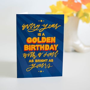 Cartão dourado de aniversário escrito à mão