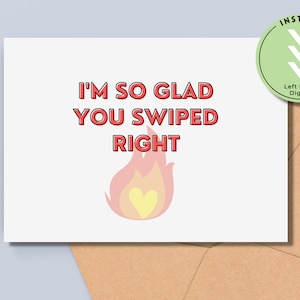 May include: Printable card with the text "I'm so glad you swiped right" in red with a pink and yellow flame graphic with a heart in the center.