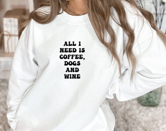May include: White sweatshirt with black text that reads "All I need is coffee, dogs and wine".