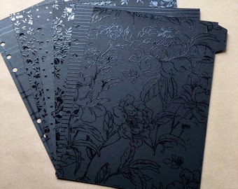 May include: A set of black patterned paper sheets with a floral design. The paper is embossed with a shiny finish.