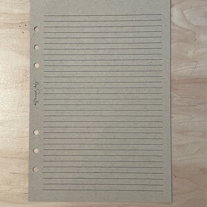 May include: A blank, lined, brown paper page with holes on the left side for a binder. The page has the text "My Story" written on it.