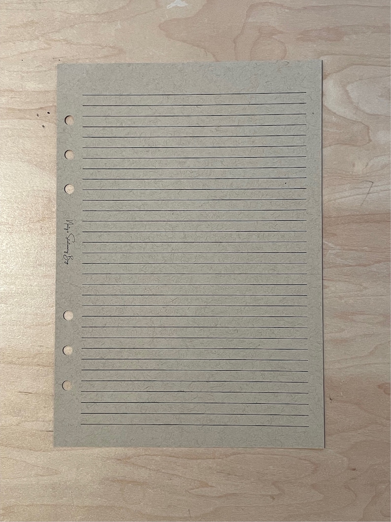 May include: A blank, lined, brown paper page with holes on the left side for a binder. The page has the text "My Story" written on it.