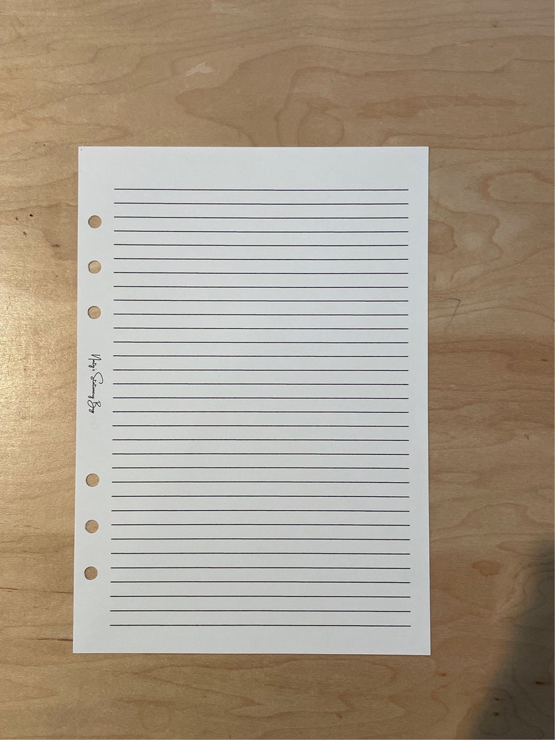 May include: A white lined paper with holes on the left side. The paper has the text "September 2023" written on it.