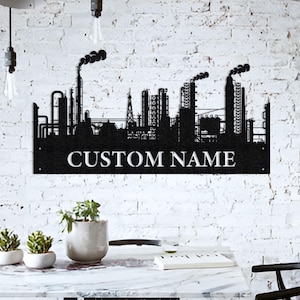 May include: Black metal silhouette of a city skyline with tall buildings and smokestacks. The skyline is mounted on a black metal plaque with the text "CUSTOM NAME" in white.