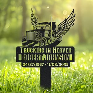 Peut inclure: Piquet de jardin en métal noir avec un semi-remorque ailé, le texte "Trucking in Heaven", le nom "Robert Johnson" et des dates. Le piquet est planté dans l'herbe.