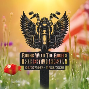 May include: A black metal memorial stake featuring a motorcycle with angel wings. The text "RIDING WITH THE ANGELS" and "ROBERT JOHNSON" are displayed, along with the dates 04/27/1967 - 11/08/2025.