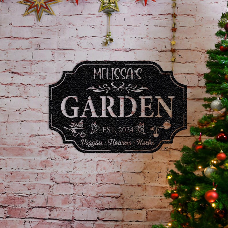 May include: Black metal garden sign with white text that reads "Melissa's Garden Est. 2024  Veggies - Flowers - Herbs".