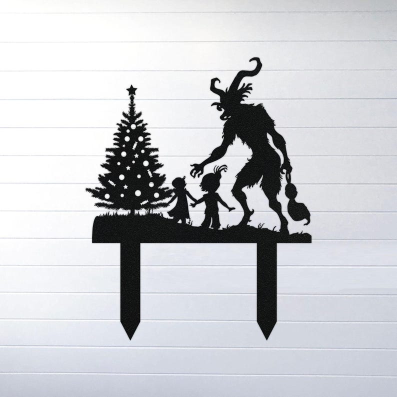 May include: Black metal Christmas yard stake featuring a silhouette of a decorated Christmas tree, two children, and a horned creature. The stake has two pointed prongs for easy placement in the ground. A festive holiday decoration.