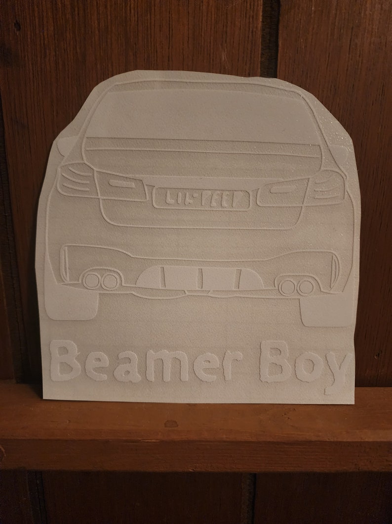 May include: White vinyl sticker of a car's rear end with the text "Beamer Boy" underneath.