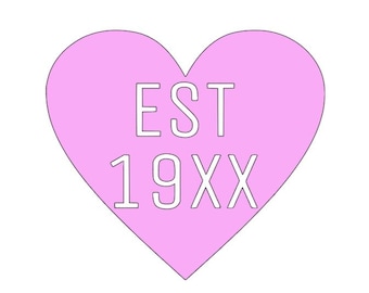 May include: A pink heart shape with the text "EST 19XX" in white. The heart is a solid color, and the text is centered within the heart. The design is simple and clean, with a minimalist aesthetic.