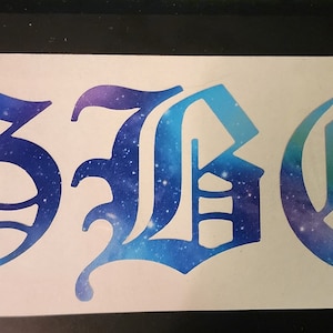 May include: A white sticker featuring the letters "GBC" in a gothic font. The letters are filled with a blue and purple galaxy design, creating a celestial effect. The sticker is rectangular.