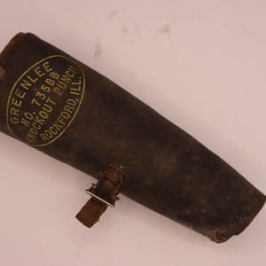 May include: A vintage leather tool pouch, dark brown in color, with a riveted construction. The pouch features a metal clasp and a label that reads "GREENLEE NO. 73588 KNOCKOUT PUNCH ROCKFORD, ILL."