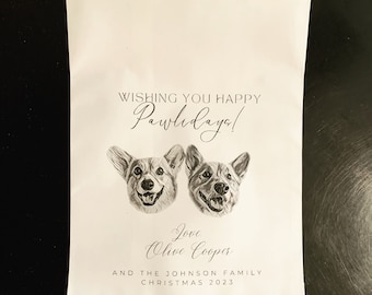 May include: White paper bag with a black and white illustration of two dogs. The text reads "Wishing you happy Pawlidays! Love Olive Cooper and the Johnson Family Christmas 2023."