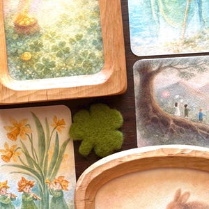 May include: Wooden trays and illustrated cards with St. Patrick, leprechauns, and rabbits. The cards show rainbows, shamrocks, and spring flowers. A green felt shamrock is also present.