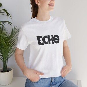 May include: White t-shirt with the word "ECHO" in bold black letters and a small skull graphic. The shirt is a classic crew neck style.