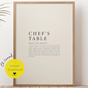 May include: A printable digital download of a minimalist black and white poster with the text "CHEF'S TABLE" and a definition of the term. The poster is framed and displayed on a wall with a wicker chair and a woven basket in the foreground.