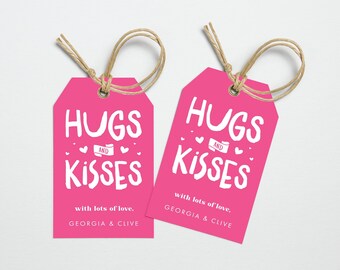 May include: Two pink gift tags with white text that reads "Hugs and Kisses" with lots of love, Georgia & Clive. The tags are tied with twine.