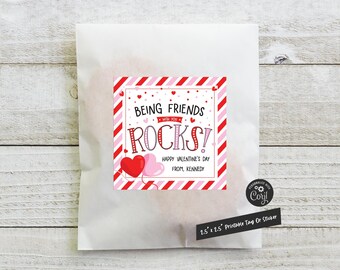 May include: Printable Valentine's Day gift tag with red and white stripes, two red and pink hearts, and the text "Being Friends with you Rocks! Happy Valentine's Day from, Kennedy".