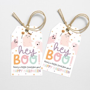 以下が含まれることがあります： カラフルなゴーストをテーマにした白いギフトタグ2枚。タグには「hey BOO! here's a little treat for you! HAPPY HALLOWEEN」と書かれています。