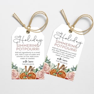 Könnte beinhalten: Zwei weiße Geschenkanhänger mit einem Aquarelldesign aus Orangen, Zimtstangen und Grün. Der Text auf den Anhängern lautet "Holiday Simmering Potpourri" und enthält Anweisungen zur Herstellung von Potpourri. Die Anhänger sind mit Schnur gebunden.